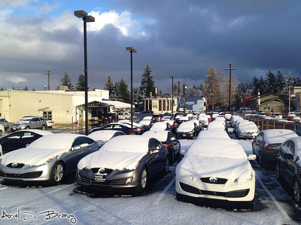 The clouds break to let the sun shine on the snow-covered cars The clouds break to let the sun shine on the snow-covered cars